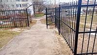 Металлический забор с калиткой и декоративными кованными элементами
